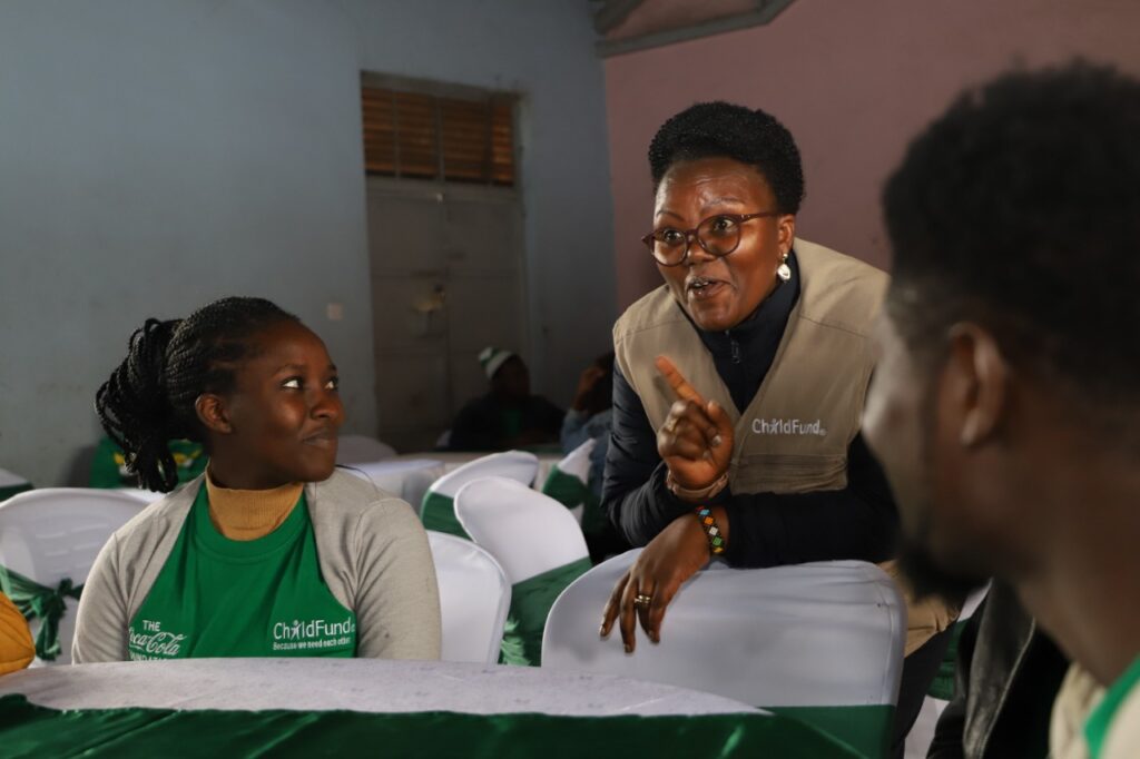 ChildFund Kenya Country Director Alice Anukur chats with youthful participants during the launch of the Tunawiri Na Taka waste management programme in Mukuru slum in Nairobi.