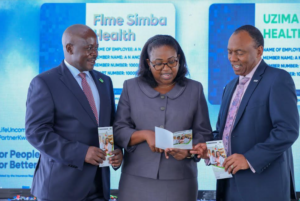 L: R- KCB Bancassurance Intermediary Limited Managing Director Aggrey Mulumbi, Insurance Regulatory Authority Supervision Manager, Teresa Mburu, and Britam Holdings Group MD Tom Gitogo hold a dummy insurance card during the launch of Uzima Tele Health plan between KCB group and Britam Insurance at CB Jogoo Road branch today.