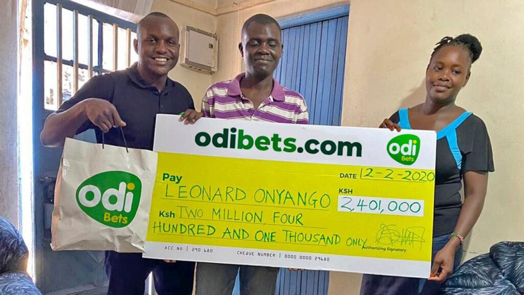 Leonard Onyango, a previous winner with OdiBets, receives a cheque from Odibets marketing manager Aggrey Sayi after winning Ksh2.4million.