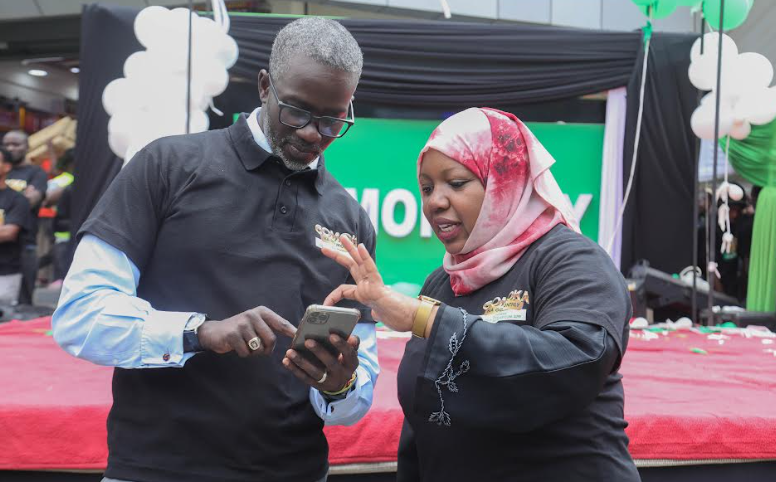 Safaricom Chief Corporate Affairs Stephen Kiptiness and Safaricom Chief Officer Consumer Business, Fawzia Ali Kimanthi peruse through some of the Go Monthly plans on the phone moments after the launch of Gomoka na Safaricom monthly plans promotion in Eastleigh today.