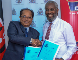 Crown Paints Kenya PLC General Manager Abhijit Roy (left) shake hand with the outgoing Vice Chancellor University of Nairobi Prof Stephen Kiama as they exchange MoU documents after the paint firm donated Ksh 1 million to help repair facilities of the Department of Urban and Regional Planning at the university as part of its corporate programs.