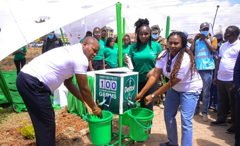 L-R Deputy Governor Machakos County,H.E Hon Francis Mwangangi and Public Health and Proffesional Standards ,PS Mary Muthoni (R) getting their hands washed by Joan Kimani during the Global handwashing day event