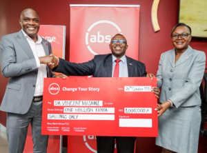 Absa Bank Kenya Customer Network and Distribution Director Peter Mutua and Sarit Branch Manager Catherine Odawa (R) award Dr. Vincent Masawi (C) with a KES. 1 million cheque as the first winner in the Bank's Change Your Story card campaign that aims to inspire consumers to embrace digital channels and card payments.