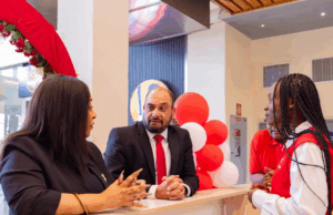 Airtel Kenya MD Ashish Malhotra (C) and Customer Experience Director Goldermier Opiyo (L) engage with Airtel Agent Sharon Sibiya during the opening of Airtel's new customer care shop at Garden City Mall, one of four new shops recently opened to bring services and support closer to customers.