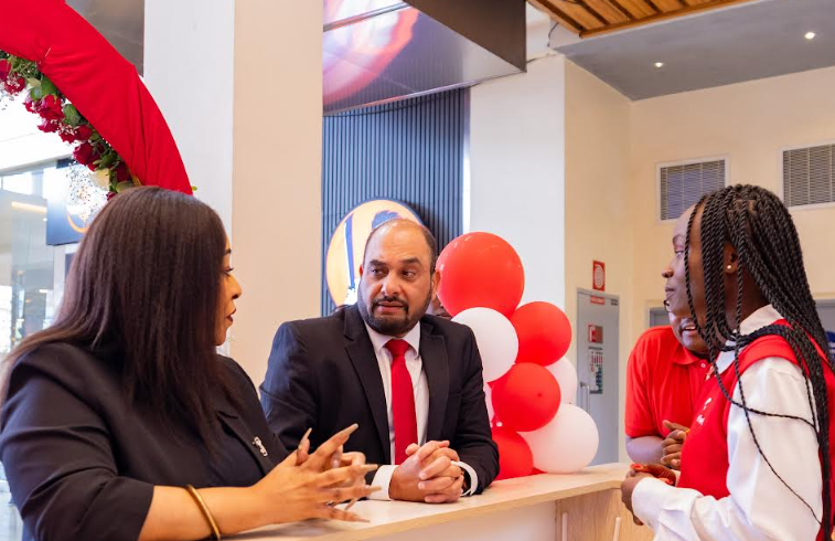 Airtel Kenya MD Ashish Malhotra (C) and Customer Experience Director Goldermier Opiyo (L) engage with Airtel Agent Sharon Sibiya during the opening of Airtel's new customer care shop at Garden City Mall, one of four new shops recently opened to bring services and support closer to customers.